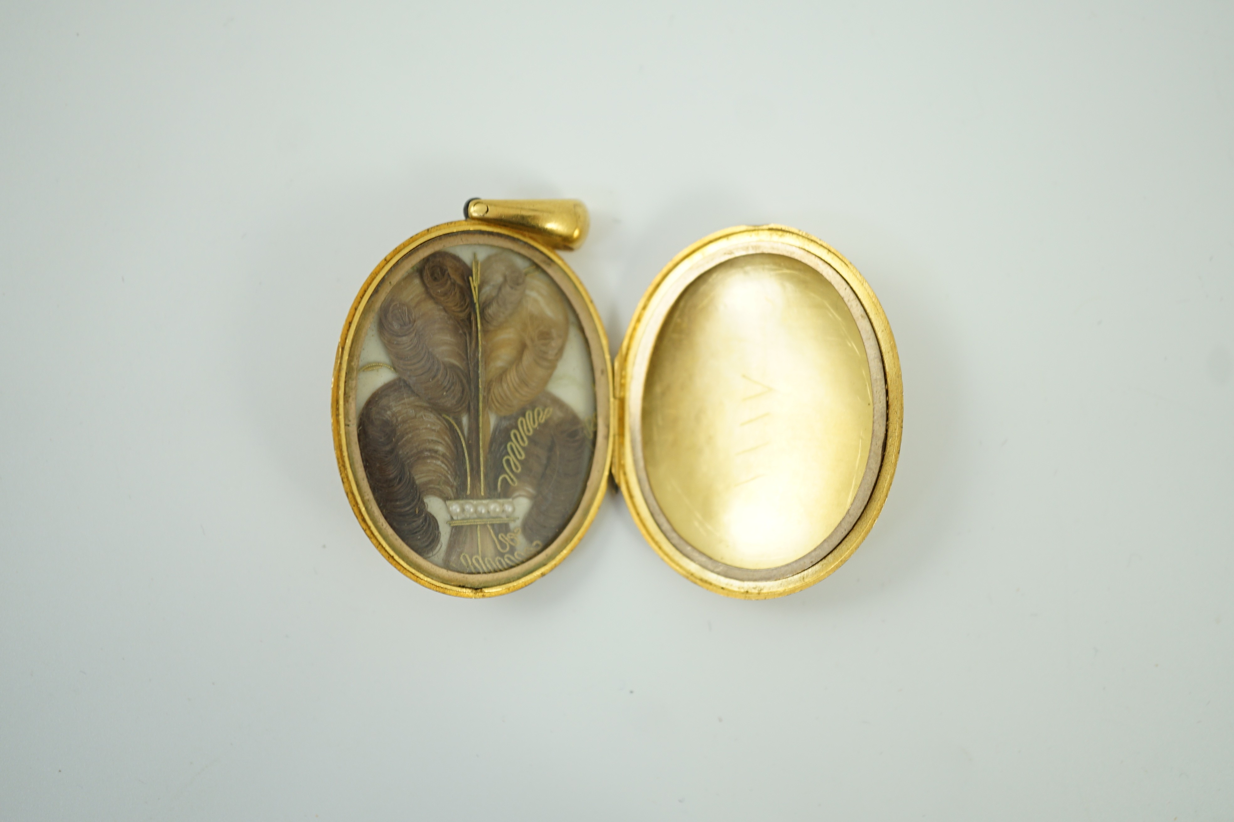 A Victorian engraved yellow metal, blue enamel and seed pearl set oval locket, 45mm, gross weight 21.2 grams.